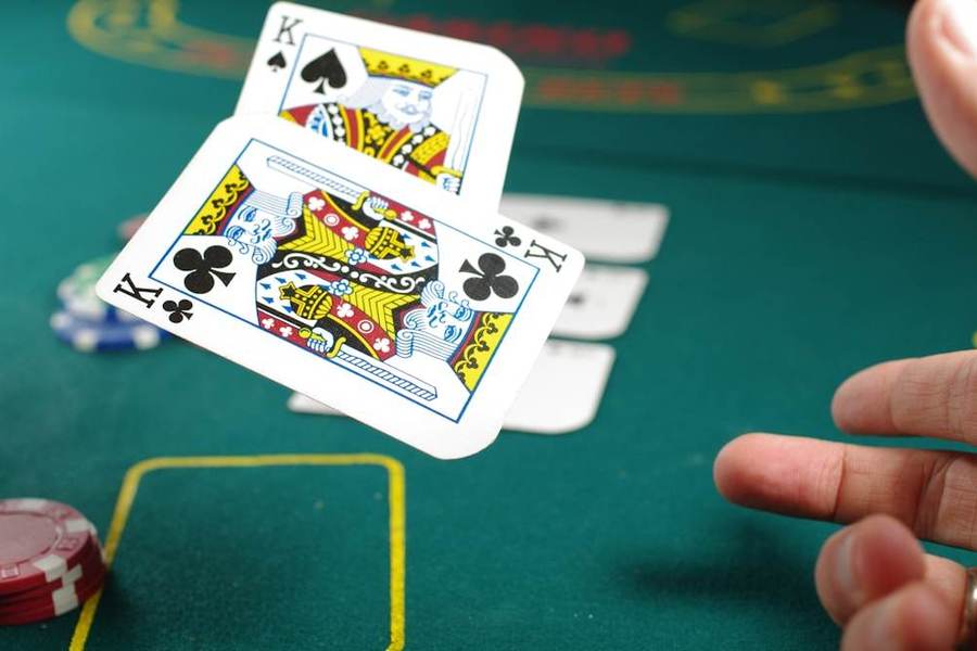 Pemain poker memegang kartu di atas meja